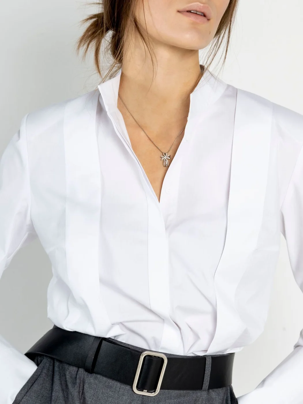 White shirt with an open collar and black belt.
