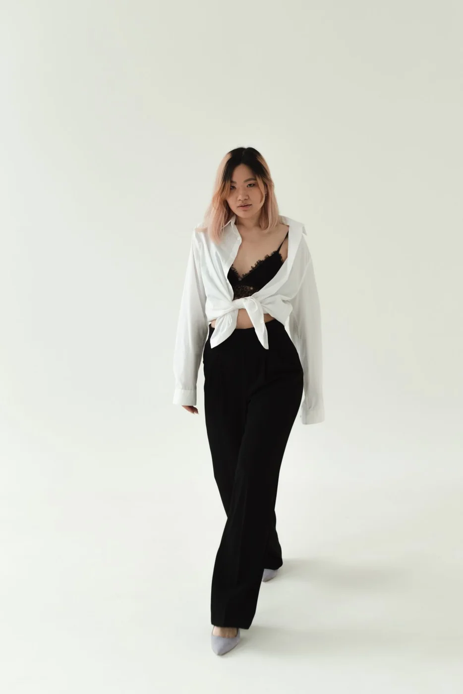 Black trousers with a light shirt tied at the front.