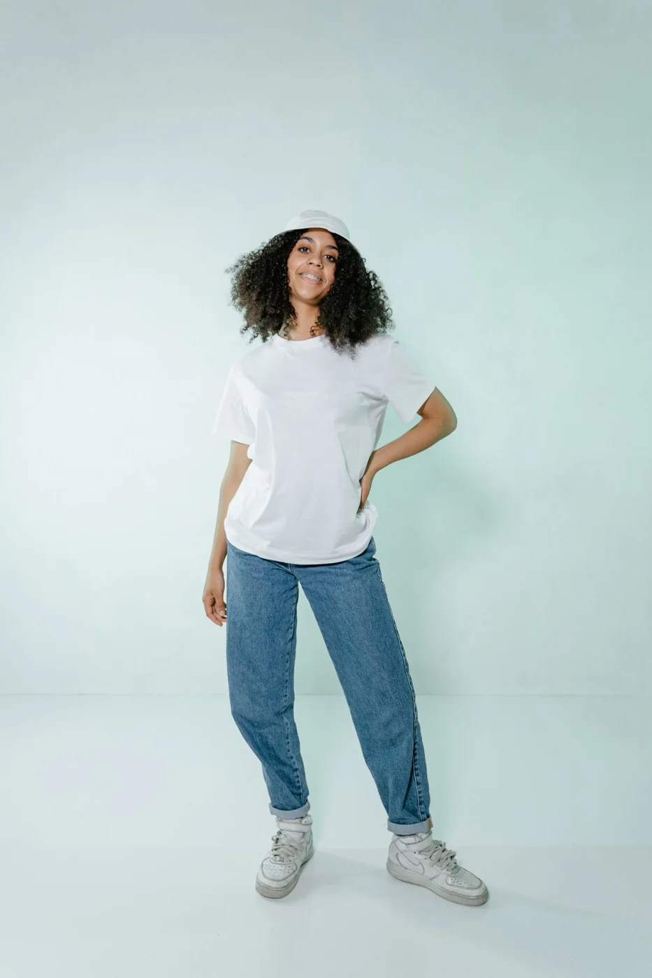 Plain white T-shirt with blue jeans and trainers.