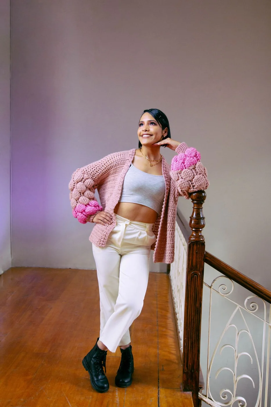 Open pink cardigan with white trousers.