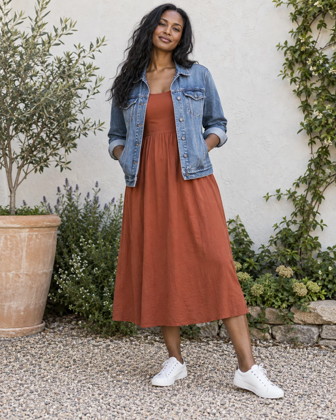 Blue denim jacket over a rust dress with trainers.