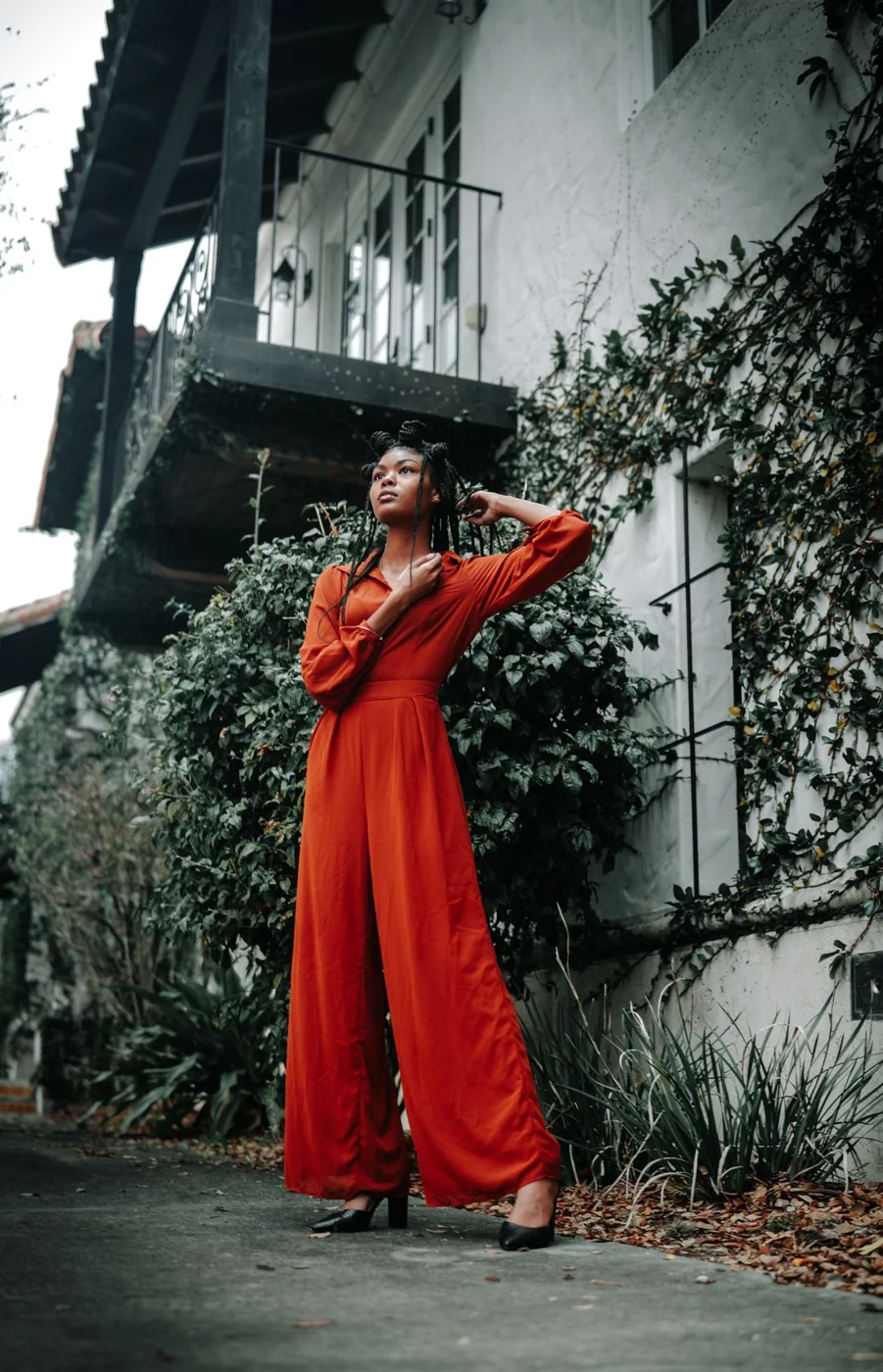 Woman in a red jumpsuit and light shoes.