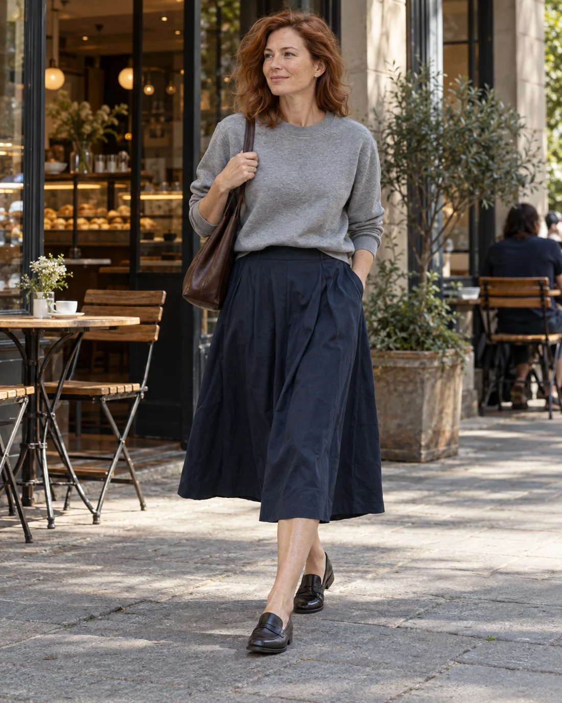 Grey sweatshirt with a navy midi skirt and loafers.