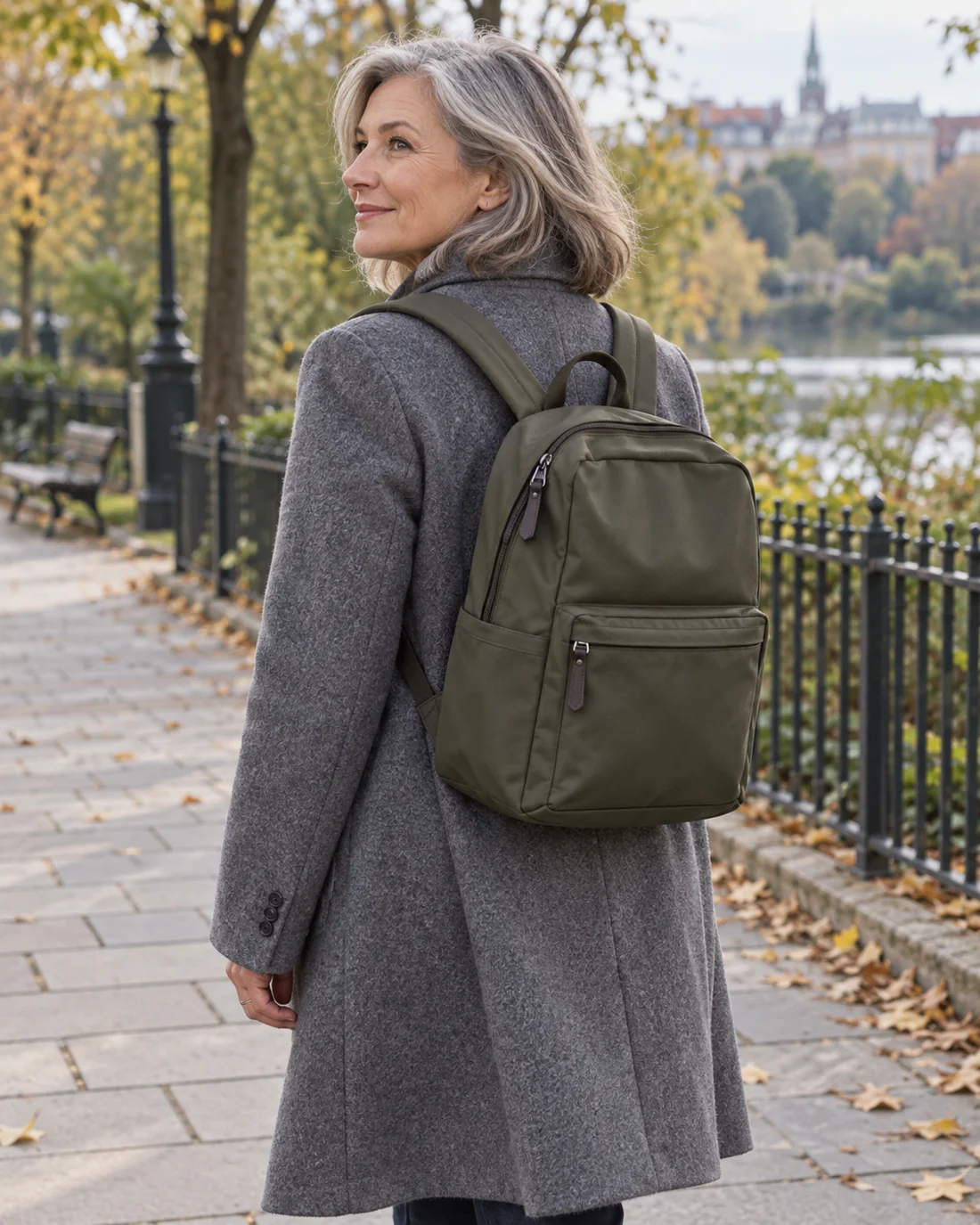 Olive backpack worn over a grey wool coat.