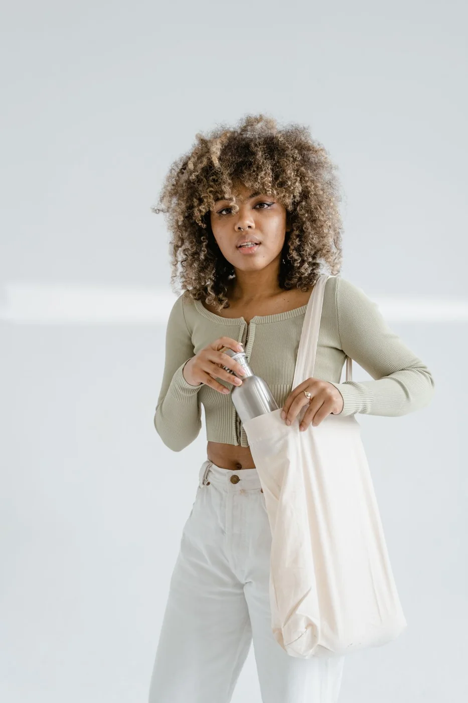 Woman putting a water bottle into a fabric tote.
