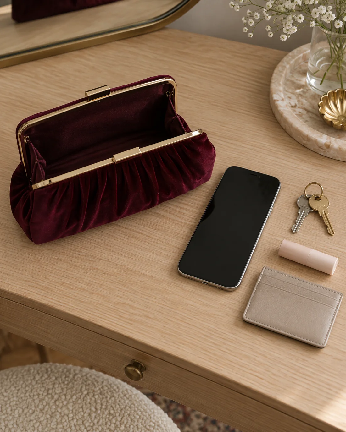 Small evening bag beside a phone, keys and card holder.