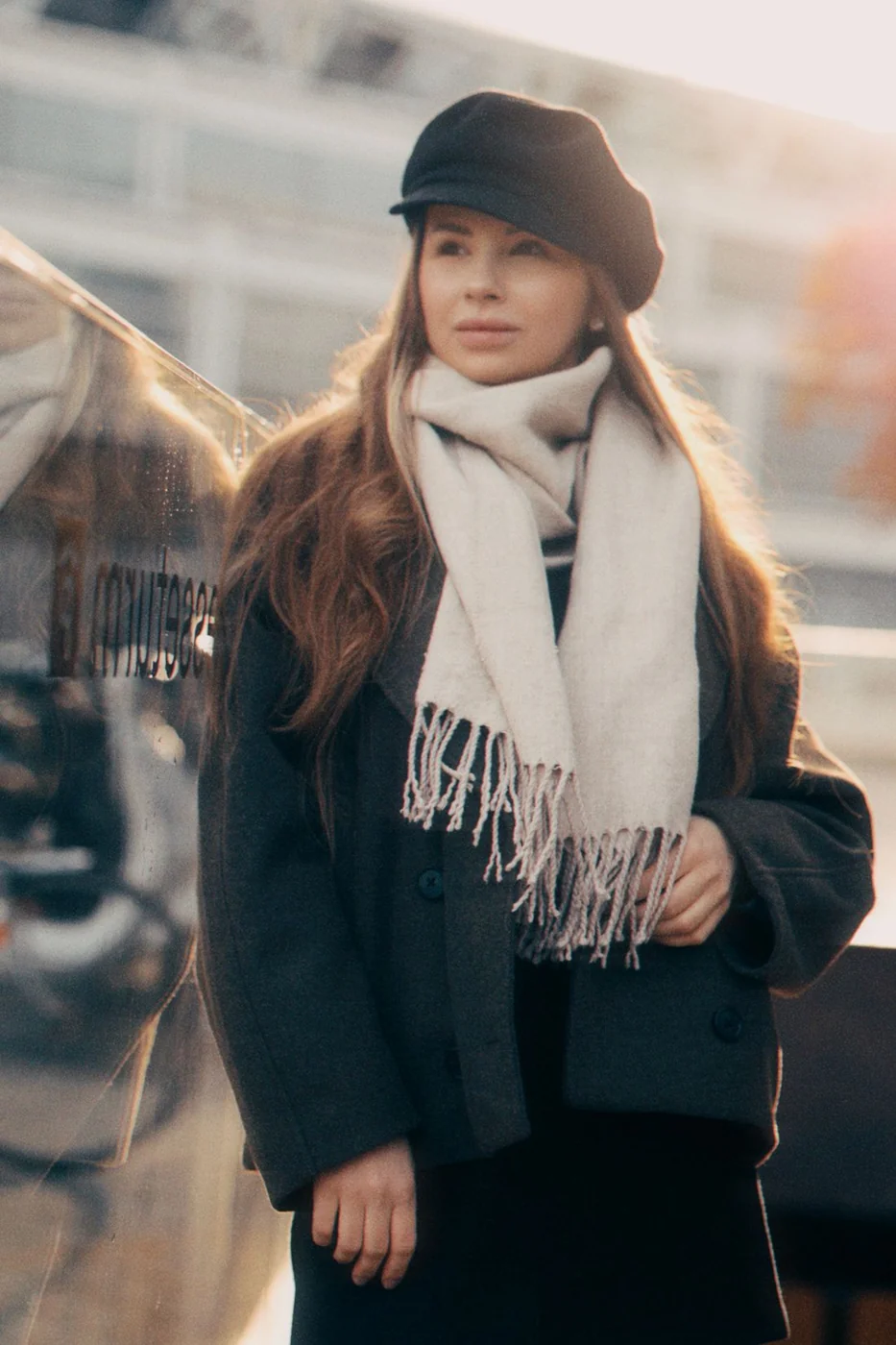 Black cap and light scarf paired with a dark coat.