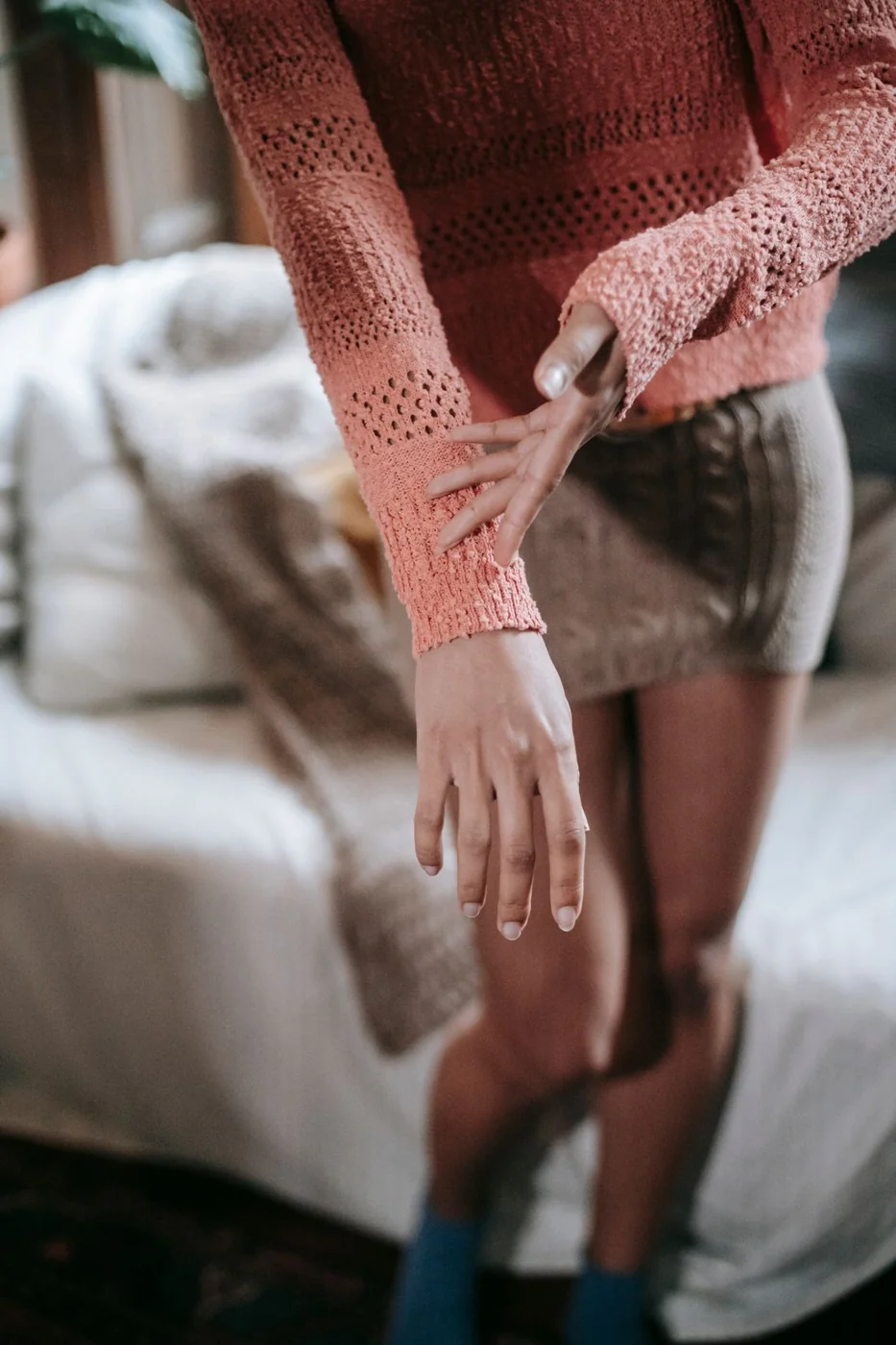 Woman showing the sleeve cuff of her knitted jumper.